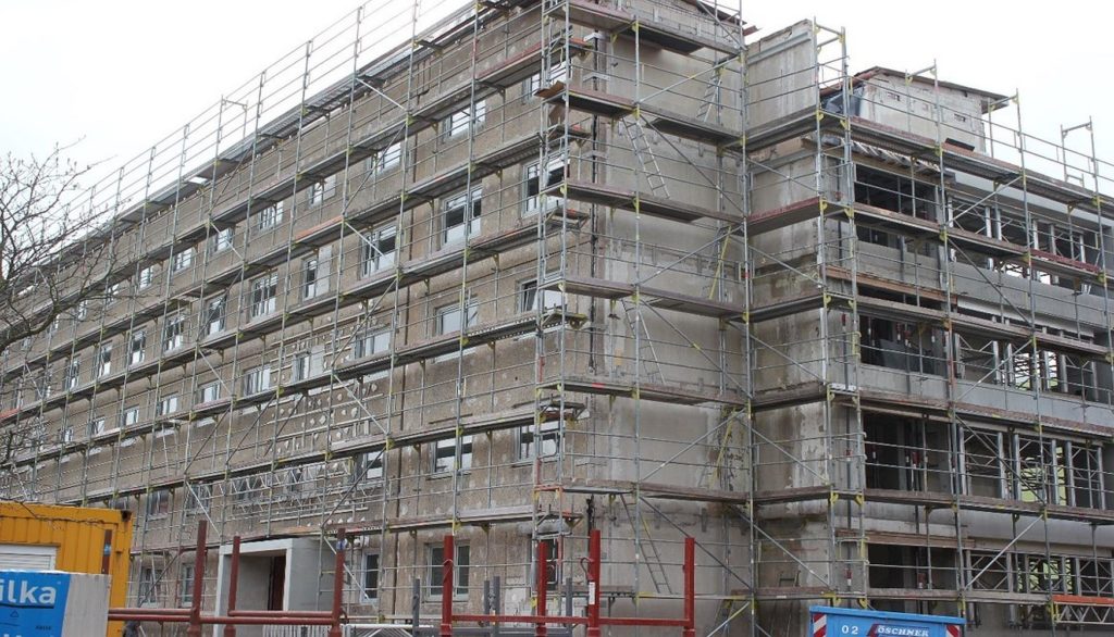 Der ganze Block ist von einem Gerüst umgeben. Die Fassade wurde angepasst, in dem Fenster verschlossen wurden.