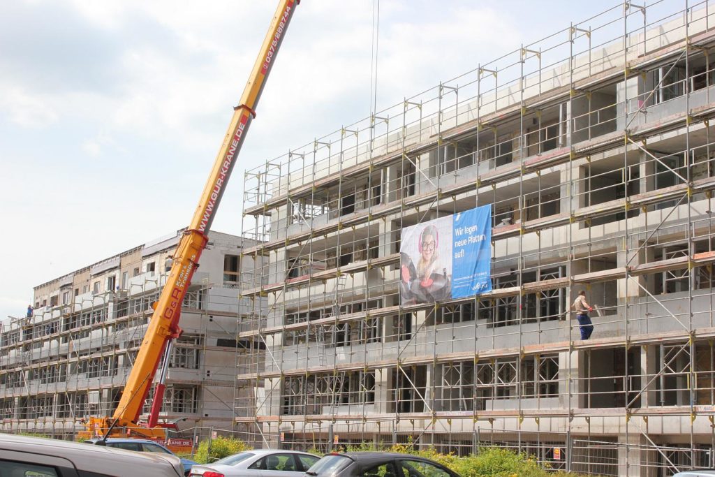 Vor der ehemaligen Fassade ist ein Anbau mit Balkonen für die Wohnungen entstanden. Noch ist alles mit einem Gerüst umhüllt.